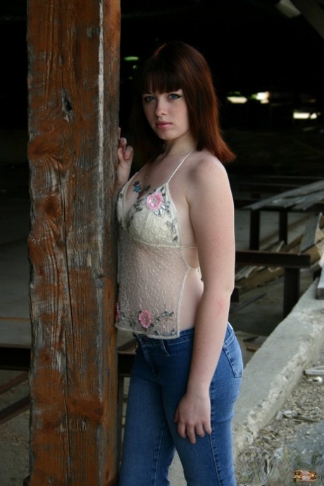 Young redhead B4rbi3 cradles a breast in jeans on a construction site 84755448