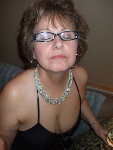 Busty mature woman sucks on a sex toy attired in crotchless lingerie 80630281