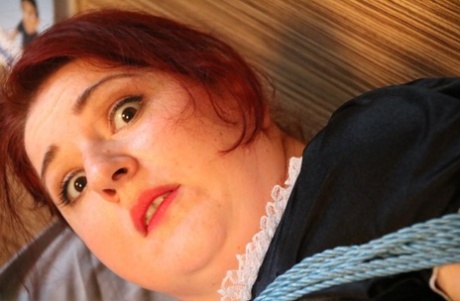 Natural redhead is left tied up on a bed in her maid uniform 38580666