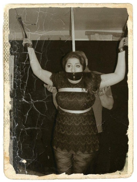 Pale redhead is silenced with a gag while restrained by her wrists in clothes 67881082