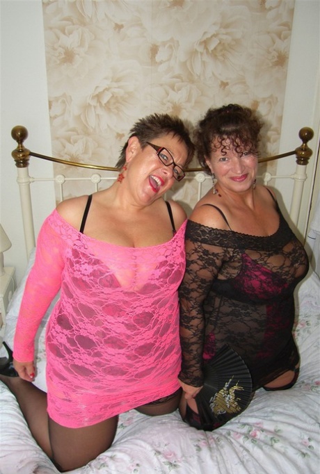 Old lesbians hump each on a bed while fully clothed and waving fans 51196189