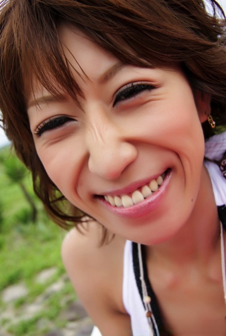 Pretty Japanese woman displays her cleavage over a cocktail near the ocean 29765318