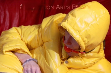 Caucasian girl is left ball gagged and restrained with chain in nylon rainwear 25543537