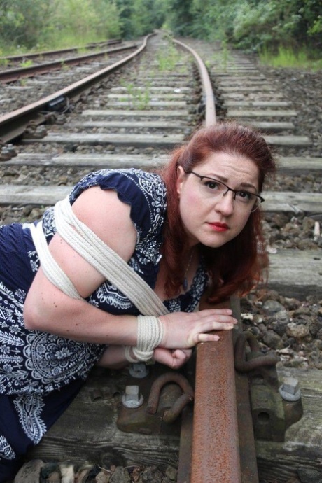 Fully clothed redhead is left gagged and bound on railway tracks 75694534