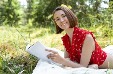 Nice teen Ava reads a book before posing nude outdoors on a blanket 20086704