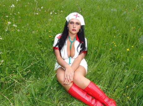 Dark haired nurse exposes her big boobs near the woods in red latex boots