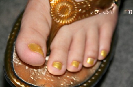 Caucasian female displays her painted toenails while wearing sandals 57649699