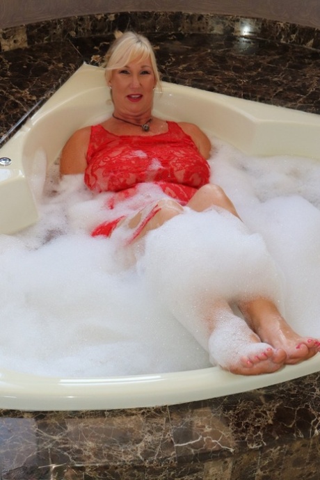 Mature fatty Melody gets in a bubble bath while fully clothed