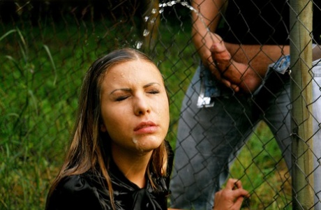 Clothed girl gets peed on after sucking off a cock thru a wire fence 75414647