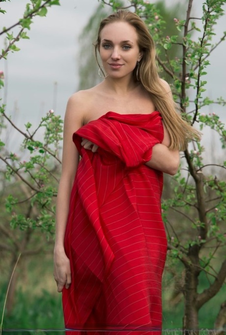 Nice teen Tayra A casts off a red wrap to model naked in an orchard 67516038